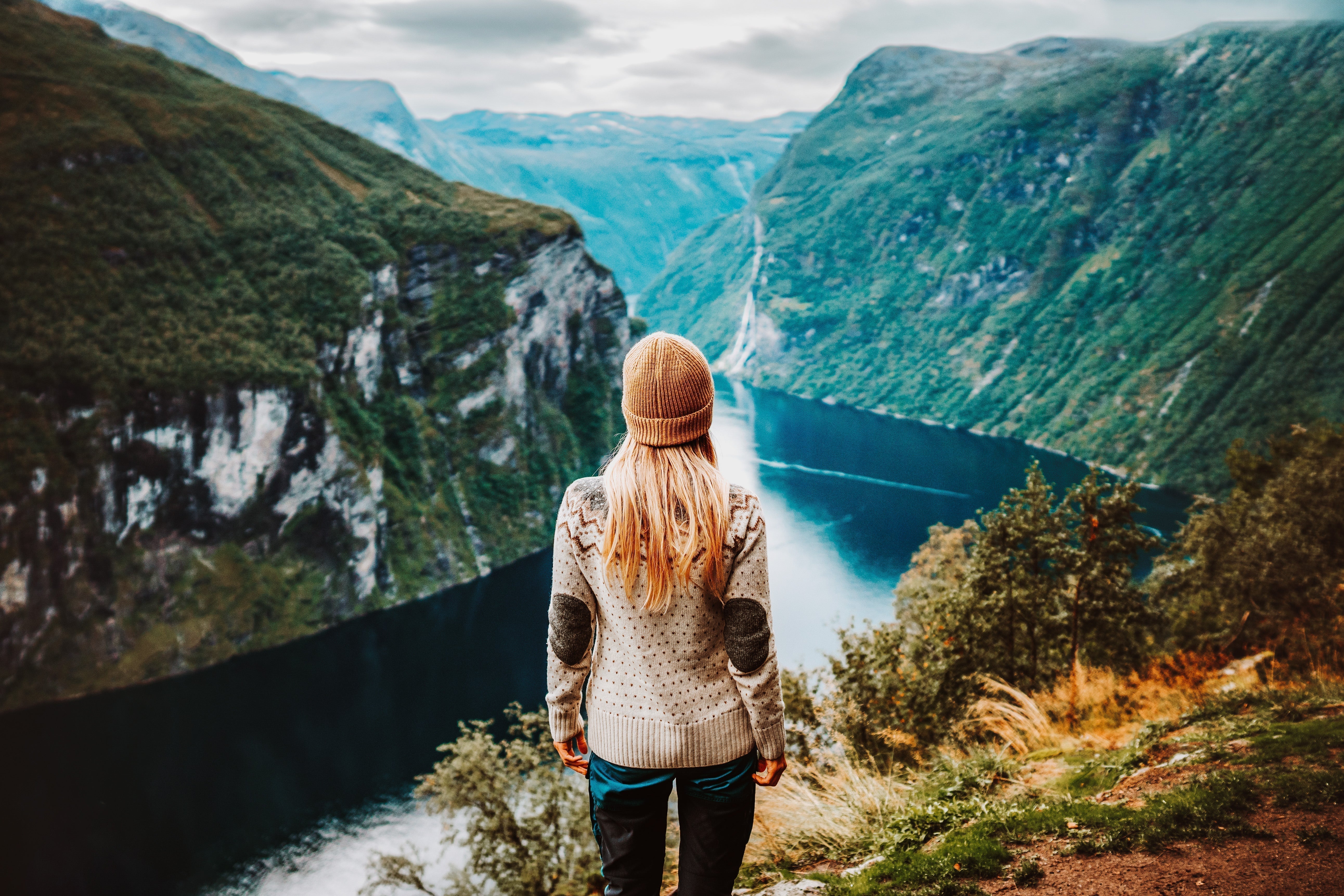 Woman standing above a Norwegian fjord in a Nordic landscape, color graded with Norway Spirit Lightroom Presets for a clean and natural look.